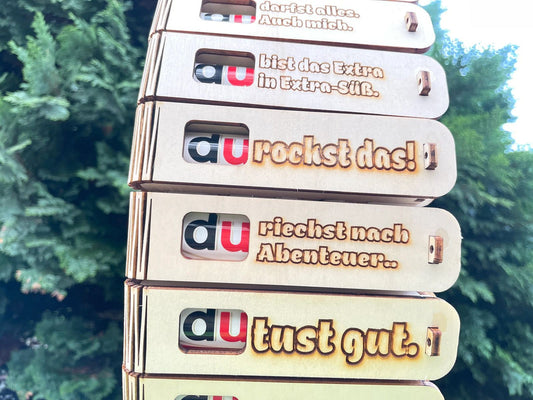 Geschenkbox „Du riechst nach Abenteuer“ mit gravierter Holzbox und Duplo Schokoriegel als originelle Überraschung