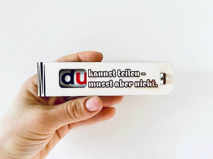 Holzgeschenkbox mit gravierter Botschaft „Du kannst teilen musst aber nicht“ und Duplo-Schokolade innen