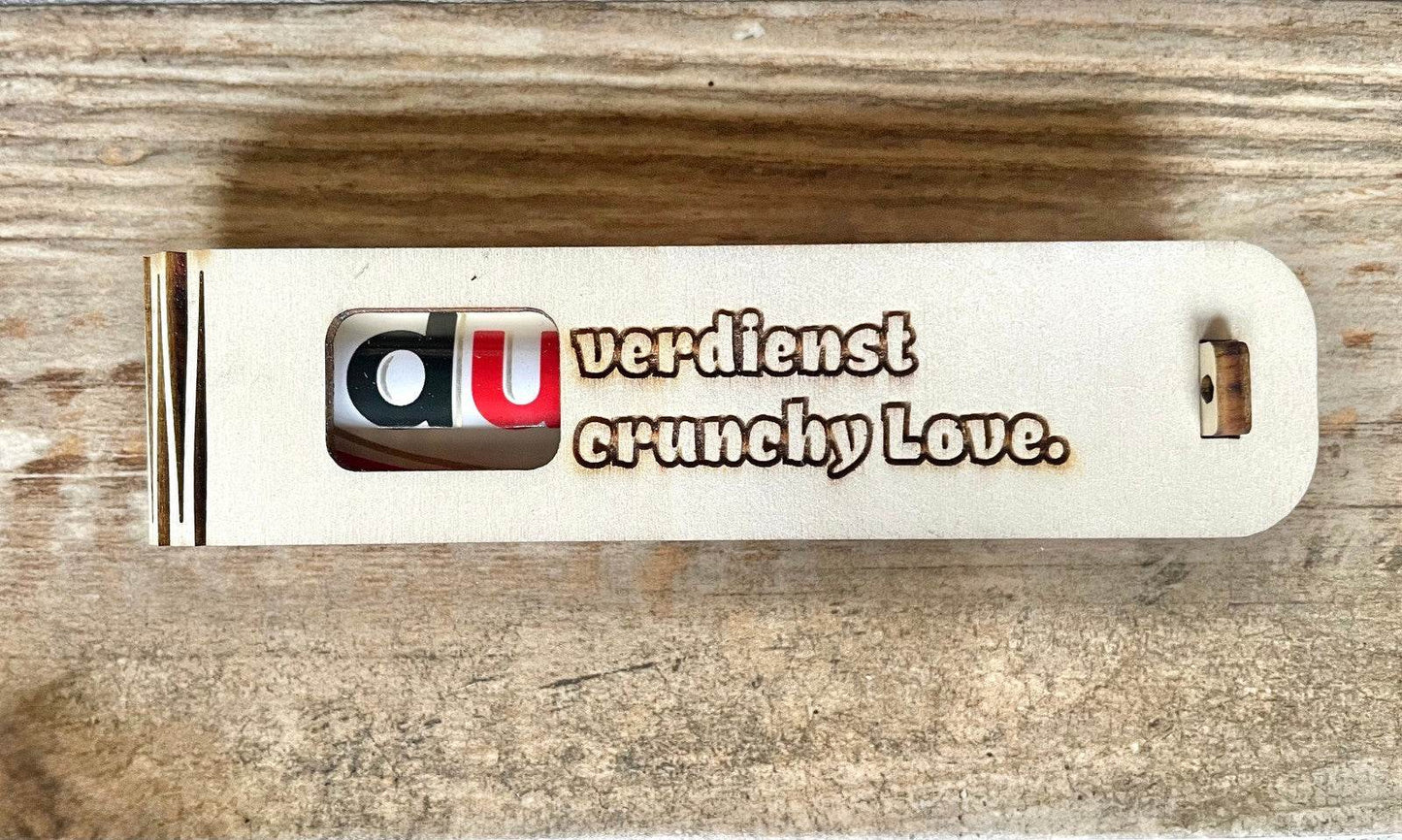 Stylish wooden gift box engraved with "Du verdienst Crunchy Love" containing a crunchy Duplo chocolate surprise inside