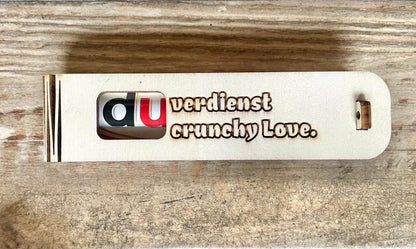 Stylish wooden gift box engraved with "Du verdienst Crunchy Love" containing a crunchy Duplo chocolate surprise inside